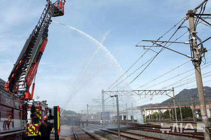 [부산=뉴시스] 하경민 기자 = 2025년 충무훈련의 하나로 '도시철도 피해복구 종합 실제훈련'이 열린 23일 부산 금정구 도시철도 1호선 노포차량정비창에서 소방이 테러로 인한 화재를 진압하고 있다. 전시 적 공격으로 인한 도시철도 시설피해 발생에 대비한 민·관·군·경·소방 합동훈련에는 53사단 부산여단과 부산교통공사, 금정구청, 금정소방서, 보건소, 부산항만공사, 금정결찰서 등 7개 기관 200여 명이 참가했다. 2025.04.23. yulnetphoto@newsis.com