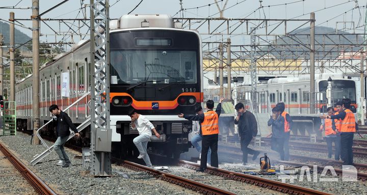 [부산=뉴시스] 하경민 기자 = 2025년 충무훈련의 하나로 '도시철도 피해복구 종합 실제훈련'이 열린 23일 부산 금정구 도시철도 1호선 노포차량정비창에서 테러를 당한 도시철도 승객들이 대피하고 있다. 전시 적 공격으로 인한 도시철도 시설피해 발생에 대비한 민·관·군·경·소방 합동훈련에는 53사단 부산여단과 부산교통공사, 금정구청, 금정소방서, 보건소, 부산항만공사, 금정결찰서 등 7개 기관 200여 명이 참가했다. 2025.04.23. yulnetphoto@newsis.com