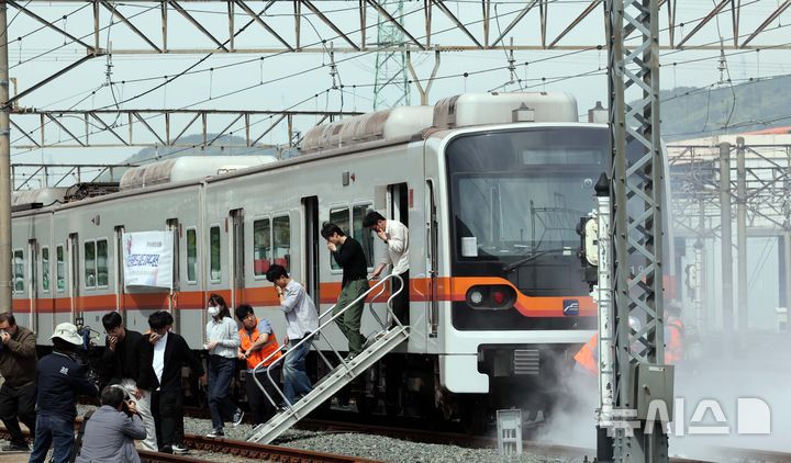 [부산=뉴시스] 하경민 기자 = 2025년 충무훈련의 하나로 '도시철도 피해복구 종합 실제훈련'이 열린 23일 부산 금정구 도시철도 1호선 노포차량정비창에서 테러를 당한 도시철도 승객들이 대피하고 있다. 전시 적 공격으로 인한 도시철도 시설피해 발생에 대비한 민·관·군·경·소방 합동훈련에는 53사단 부산여단과 부산교통공사, 금정구청, 금정소방서, 보건소, 부산항만공사, 금정결찰서 등 7개 기관 200여 명이 참가했다. 2025.04.23. yulnetphoto@newsis.com