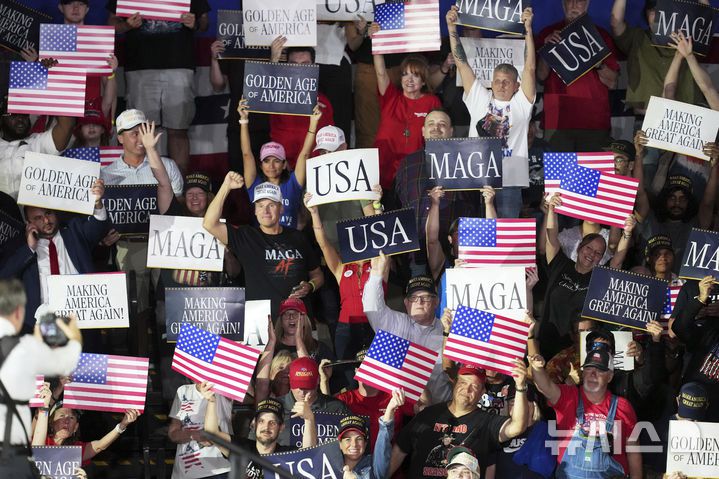 [워런(미시간주)=AP/뉴시스] 29일(현지 시간) 미국 미시간주 워런의 머콤 카운티 커뮤니티 컬리지 스포츠 엑스포 센터에서 열린 도널드 트럼프 미국 대통령 취임 100일 기념 집회에서 지지자들이 환호하고 있다. 2025.04.30.