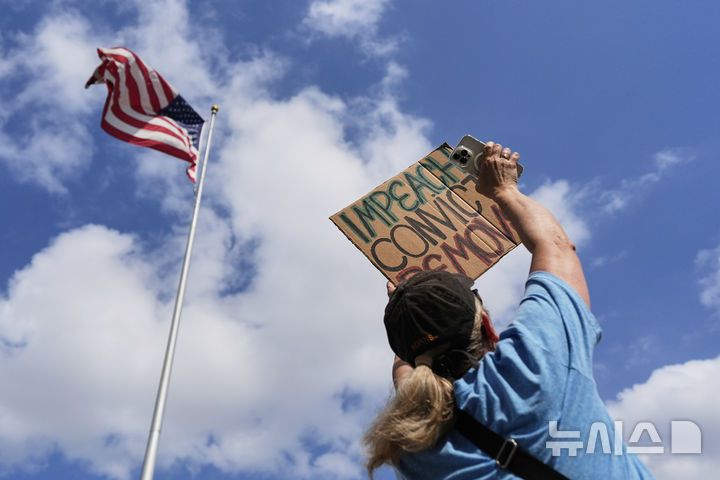 [휴스턴=AP/뉴시스] 1일(현지 시간) 미국 텍사스주 휴스턴 시청 앞에서 열린 노동절 시위에 참여한 한 시민이 반트럼프 팻말을 들고 있다. 2025.05.02.