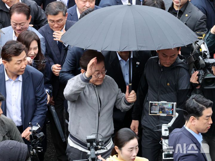 [속초=뉴시스] 조성우 기자 = 민심을 청취하는 '경청 투어'에 나선 이재명 더불어민주당 대선후보가 3일 강원도 속초시 속초중앙시장을 방문하기 위해 차에서 내려 경호를 받으며 이동하고 있다. 이 후보 측은 "후보에 대한 피습 모의 제보가 잇따르고 있다"고 밝혔다. 2025.05.03. xconfind@newsis.com