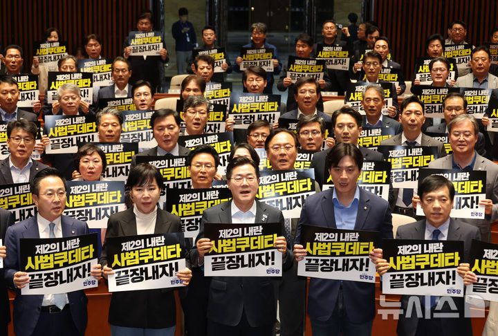 [서울=뉴시스] 고승민 기자 = 더불어민주당 박찬대 대표 직무대행 겸 원내대표와 의원들이 4일 서울 여의도 국회에서 열린 긴급 의원총회에서 피켓을 들고 구호를 외치고 있다. 2025.05.04. kkssmm99@newsis.com