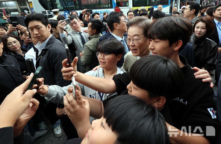 [옥천=뉴시스] 조성봉 기자 = 민심을 청취하는 '경청 투어'에 나선 이재명 더불어민주당 대선후보가 6일 충북 옥천군 옥천공설시장에서 어린이들과 셀카를 찍고 있다. 2025.05.06. suncho21@newsis.com