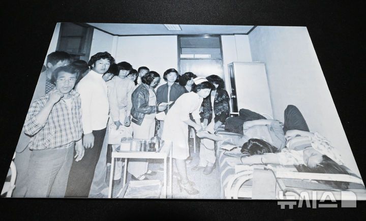 [광주=뉴시스] 이영주 기자 = 6일 오후 광주 동구 옛적십자병원에서 이창성 전 중앙일보 기자가 5·18 당시 촬영했던 병원 내 헌혈 장면이 담긴 사진이 전시되고 있다. 옛적십자병원은  5·18민주화운동 45주기를 맞아 5월 한달 동안 임시개방된다. 2025.05.06. leeyj2578@newsis.com