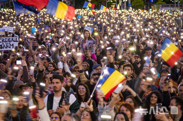 [부쿠레슈티=AP/뉴시스] 11일(현지 시간) 루마니아 부쿠레슈티에서 열린 니쿠쇼르 단 대선 후보 유세 현장에서 지지자들이 휴대전화 플래시를 밝히며 응원하고 있다.  2025.05.19.