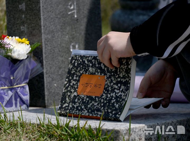 [광주=뉴시스] 김혜인 기자 = 광주 5·18민주화운동 45주년 엿새를 앞둔 12일 오전 광주 북구 국립 5·18민주묘지에서 학생들이 한강 작가의 '소년이 온다' 책 주인공 '동호' 실존 인물인 문재학 열사의 묘소를 참배하던 중 소설 '소년이 온다'를 제단에 바치고 있다. 2025.05.12. hyein0342@newsis.com