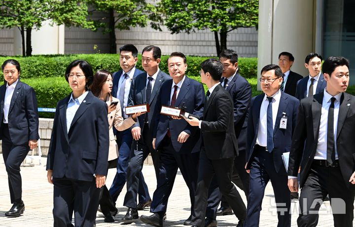 [서울=뉴시스] 사진공동취재단 = 12·3 비상계엄 사태와 관련해 내란 우두머리 혐의 등으로 기소된 윤석열 전 대통령이 12일 서울 서초구 서울중앙지방법원에서 열린 3차 공판에서 오전 공판을 마치고 법원을 나서고 있다. 2025.05.12. photo@newsis.com