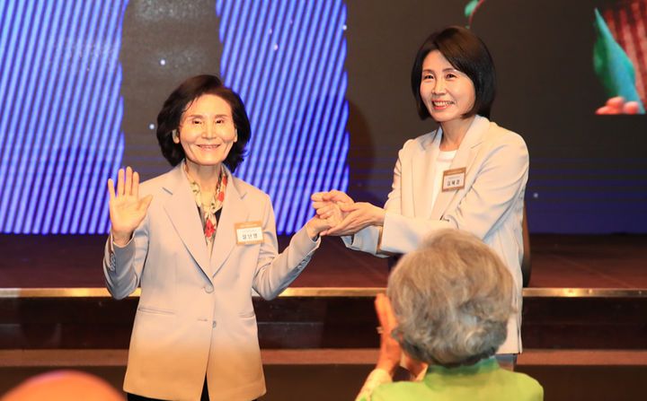 [서울=뉴시스] 조성봉 기자 = 이재명 더불어민주당 대선 후보의 부인 김혜경 여사와 김문수 국민의힘 대선후보의 부인 설난영(왼쪽) 여사가 12일 서울 중구 신라호텔에서 열린 중앙신도회 창립 70주년 기념식에서 손을 맞잡고 있다.(사진=조계종 제공) 2025.05.13. photo@newsis.com *재판매 및 DB 금지