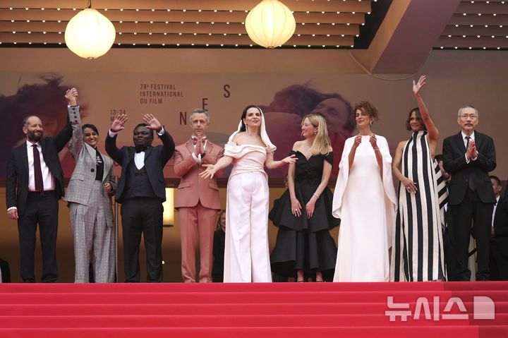 [칸=AP/뉴시스] 홍상수(오른쪽) 감독이 심사위원장인 쥘리에트 비노슈 등과 함께 13일(현지 시간) 프랑스 남부 칸에서 열린 제78회 칸 국제영화제 개막식 레드카펫 행사에 참석하고 있다. 홍 감독은 심사위원으로 이 자리에 함께했다. 2025.05.14.