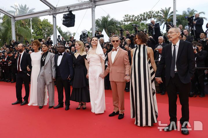 [칸=AP/뉴시스] 홍상수(오른쪽) 감독이 심사위원장인 쥘리에트 비노슈 등과 함께 13일(현지 시간) 프랑스 남부 칸에서 열린 제78회 칸 국제영화제 개막식 레드카펫 행사에 참석하고 있다. 홍 감독은 심사위원으로 이 자리에 함께했다. 2025.05.14.