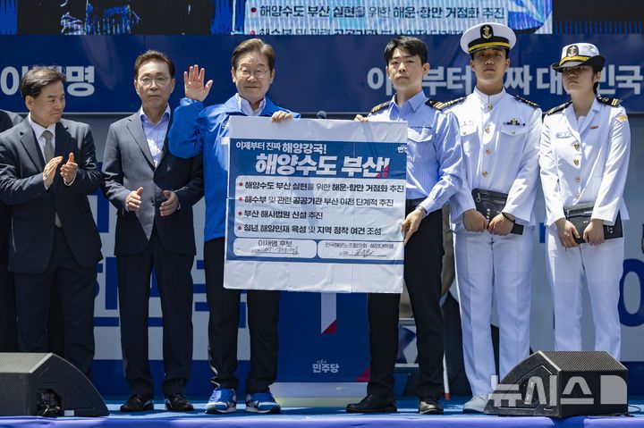 [부산=뉴시스] 권창회 기자 = 이재명 더불어민주당 대선 후보가 14일부산 부산진구 서면 젊음의 거리에서 열린 유세에서 권기흥 에이치라인해운해상직원노조 위원장과 해양수도 부산 협약서에 서명한 뒤 기념촬영을 하고 있다. (공동취재) 2025.05.14. photo@newsis.com