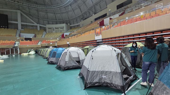 [광주=뉴시스] 박기웅 기자 = 17일 오전 광주 광산구 소촌동 금호타이어 광주공장 화재 현장에서 발생한 검은 연기와 유독가스가 인근 주택가로 퍼지자 행정 당국이 대피소를 마련하고 있다. 이날 광산구는 광주여자대학교 체육관에 400세대가 머무를 수 있는 텐트를 설치할 예정이다. (사진 = 광주 광산구 제공) 2025.05.17. photo@newsis.com *재판매 및 DB 금지