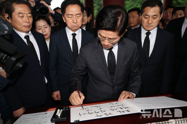 [광주=뉴시스] 조성봉 기자= 김문수 국민의힘 대통령 후보가 17일 오전 광주 북구 5.18민주묘지를 찾아 참배하기 전 방명록을 쓰고 있다. (공동취재) 2025.05.17. photo@newsis.com