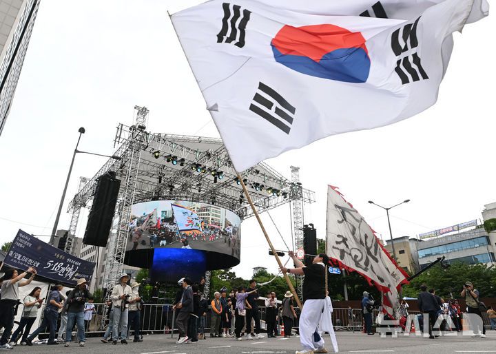 [광주=뉴시스] 이영주 기자 = 17일 오후 광주 동구 금남로에서 5·18민주화운동 45주기를 기념하는 풍물패가 대형 태극기를 흔들고 있다. 2025.05.17. leeyj2578@newsis.com