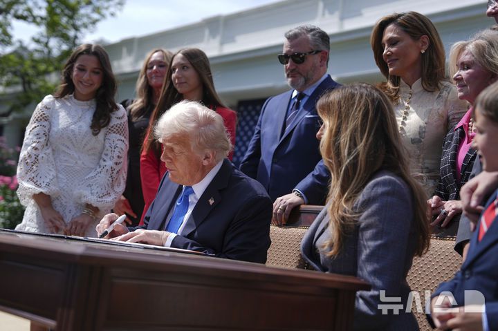 [워싱턴=AP/뉴시스] 도널드 트럼프 미국 대통령이 19일(현지 시간) 백악관 로즈가든에서 멜라니아 여사와 함께 복수 포르노 금지법인 '테이크 잇 다운' 법안(Take it Down Act)에 서명하고 있다. 이 법안은 인공지능(AI) 기반의 '딥페이크' 이미지까지 포함해 온라인에서의 사생활 침해에 강력히 대응하는 내용을 담고 있으며 멜라니아 여사도 함께 서명했다. 2025.05.20.