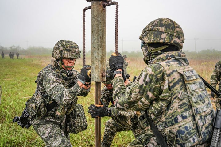 [서울=뉴시스] 서북도서방위사령부는 지난 21일부터 23일까지 백령도와 연평도 등 서북도서 일대에서 서북도서의 군사대비태세를 유지하고, 합동작전 수행능력을 향상하기 위해 2025년 전반기 합동도서방어훈련을 실시했다.사진은 21일 해병대 6여단 장병들이 합동도서방어훈련 간 백령도 지역에 적 강점에 대비하여 철조망 장애물을 설치하고 있다. (사진=해병대사령부 제공) 2025.05.23. photo@newsis.com *재판매 및 DB 금지