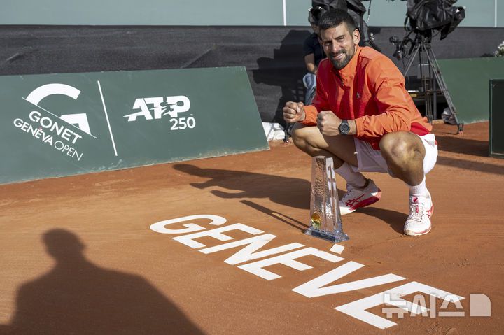 [제네바=AP/뉴시스] 노바크 조코비치(6위·세르비아)가 24일(현지 시간) 스위스 제네바에서 열린 남자프로테니스(ATP) 투어 제네바 오픈(ATP250) 정상에 올라 트로피를 들고 기념 촬영하고 있다. 조코비치는 단식 결승에서 후베르트 후르카치(31위·폴란드)에게 힘겹게 2-1(5-7 7-6 7-6) 역전승을 거두고 우승하며 ATP 투어 이상급 대회 단식 100회 우승의 대기록을 작성했다. 2025.05.25.