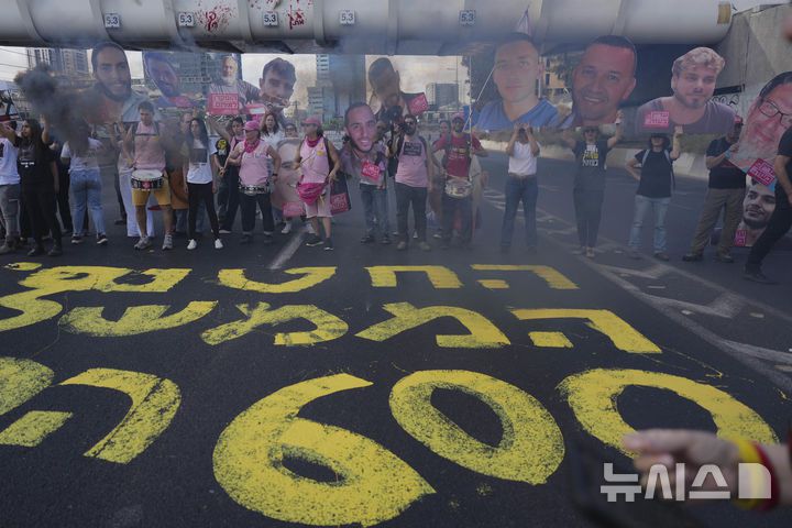 [텔아비브=AP/뉴시스] 하마스에 억류된 인질들의 가족과 지지자들이 지난달 28일(현지 시간) 억류 600일째를 맞아 이스라엘 텔아비브에서 전쟁 종식과 석방을 촉구하며 인질들의 사진을 들고 고속도로를 점거한 채 시위하고 있다. 2025.06.25.