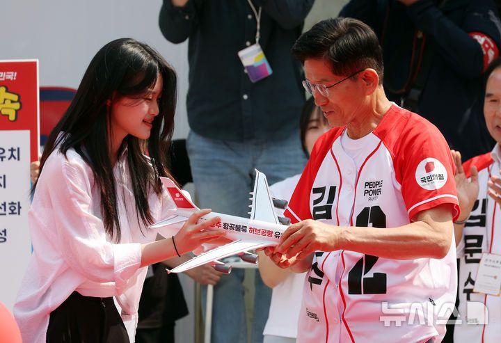 [충주=뉴시스] 고승민 기자 = 김문수 국민의힘 대선 후보가 30일 충북 충주 젊음의거리에서 유세를 하기 전 청년 참가자에게 '허브공항' 메시지가 적힌 모형 비행기를 선물받고 있다. 2025.05.30. kkssmm99@newsis.com