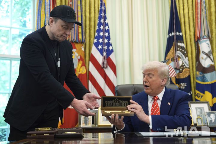 [워싱턴=AP/뉴시스]도널드 트럼프 미국 대통령이 30일(현지 시간) 백악관 집무실에서 일론 머스크 테슬라 최고경영자(CEO)를 배석한 채 기자회견을 열고 황금 열쇠를 선물하고 있다. 2025.05.31.