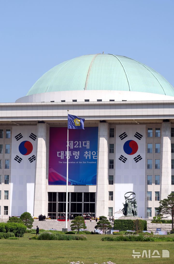 [서울=뉴시스] 조성봉 기자 = 이재명 제21대 대통령 취임선서식이 열리는 4일 오전 서울 여의도 국회 본청 외벽에 대형 태극기와 행사 현수막이 걸려 있다.  2025.06.04. suncho21@newsis.com