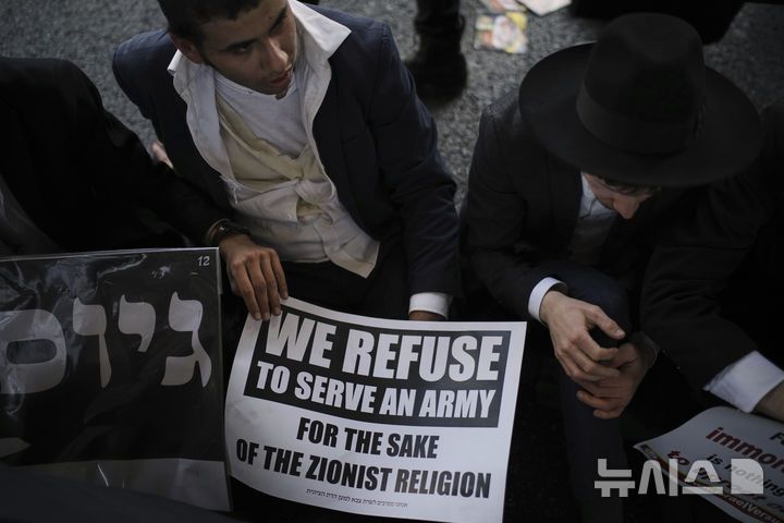 [브네이 브락=AP/뉴시스] 지난달 5일(현지 시간) 이스라엘 브네이 브락에서 '병역 거부' 손팻말을 든 초정통파 유대교 남성들이 고속도로를 막고 징집 반대 시위를 하고 있다. 2025.07.17.