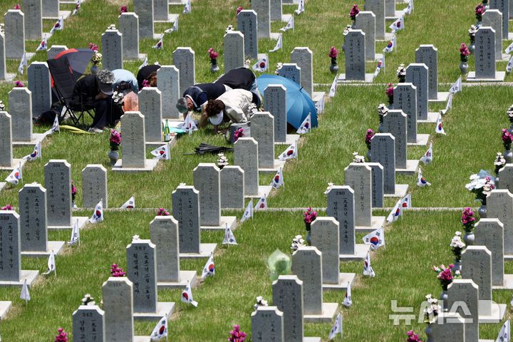 [서울=뉴시스] 김명년 기자 = 현충일을 하루 앞둔 5일 서울 동작구 국립서울현충원에서 참배객이 묘역에 절하고 있다. 2025.06.05. kmn@newsis.com