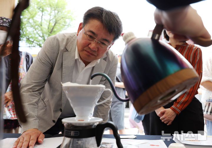 [서울=뉴시스] 김진아 기자 = 오승록 노원구청장이 8일 서울 노원구 공릉역 일대에서 열린 '제3회 경춘선 공릉숲길 커피축제'에서 카메룬 블루마운틴 공정무역커피에 대한 설명을 듣고 있다.   '커피 여행'을 주제로 열린 이번 축제에서는 케냐, 과테말라, 엘살바도르 등 세계 20여 개국의 커피를 맛보고 각국의 고유한 커피 문화도 체험해볼 수 있다. 2025.06.08. bluesoda@newsis.com