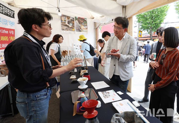 [서울=뉴시스] 김진아 기자 = 오승록 노원구청장이 8일 서울 노원구 공릉역 일대에서 열린 '제3회 경춘선 공릉숲길 커피축제'에서 카메룬 블루마운틴 공정무역커피에 대한 설명을 듣고 있다.   '커피 여행'을 주제로 열린 이번 축제에서는 케냐, 과테말라, 엘살바도르 등 세계 20여 개국의 커피를 맛보고 각국의 고유한 커피 문화도 체험해볼 수 있다. 2025.06.08. bluesoda@newsis.com
