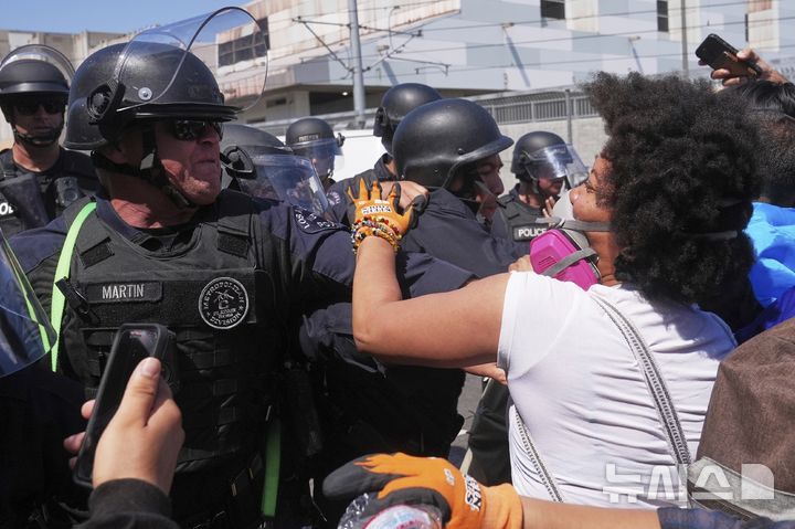 [로스앤젤레스=AP/뉴시스] 8일(현지 시간) 미 캘리포니아주 로스앤젤레스 도심에서 이민세관단속국(ICE)의 불법 이민자 단속 및 체포에 항의하는 사람들이 경찰과 충돌하고 있다. 도널드 트럼프 대통령은 불법 이민자 단속에 항의하는 시위 가담자들은 마스크를 착용해선 안 된다고 밝혔다. 2025.06.09.