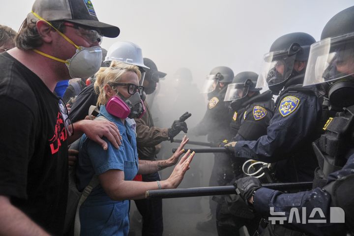 [로스앤젤레스=AP/뉴시스] 8일(현지 시간) 미 캘리포니아주 로스앤젤레스 도심 메트로폴리탄 구치소 인근 101번 고속도로에서 이민세관단속국(ICE)의 불법 이민자 단속 및 체포에 항의하는 시위대가 경찰과 대치하고 있다. 2025.06.09.