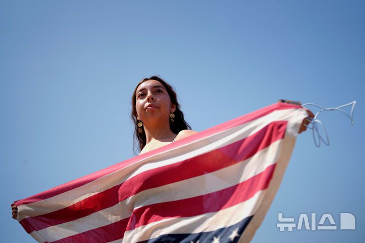 [로스앤젤레스=AP/뉴시스] 9일(현지 시간) 미 캘리포니아주 로스앤젤레스(LA) 도심에서 한 여성이 미국 국기를 거꾸로 들고 시위하고 있다. 미 군 당국은 LA 불법 이민자 단속 반대 시위에 약 700명의 해병대원을 투입한다고 공식 발표했다. 2025.06.10.