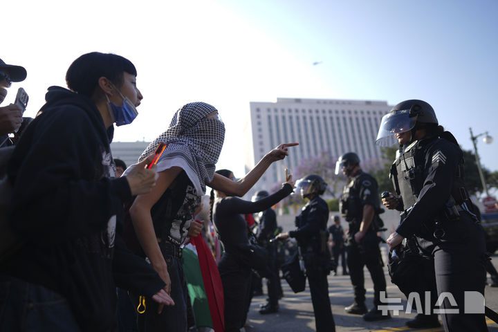 [로스앤젤레스=AP/뉴시스] 지난 9일(현지 시간) 미 캘리포니아주 로스앤젤레스(LA) 도심에서 LA 경찰이 이민세관단속국(ICE)의 불법 이민자 단속에 반대하는 시위대와 대치하고 있다. 2025.06.11.