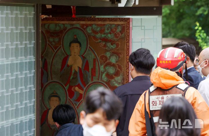 [서울=뉴시스] 김명년 기자 = 10일 오전 서울 종로구 조계사 옆 한국불교역사문화기념관 국제회의장에서 화재가 발생해 관계자들이 문화재를 옮기고 있다. 2025.06.09. kmn@newsis.com