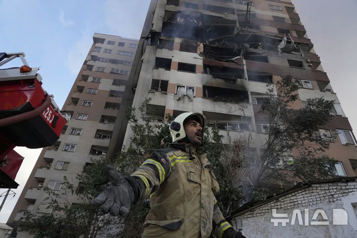 [테헤란=AP/뉴시스] 13일(현지 시간) 이란 테헤란 북부의 한 주거 단지 폭발 현장에서 한 소방관이 동료들을 급하게 찾고 있다. 이스라엘방위군(IDF)은 이날 새벽 이스라엘이 이란의 핵·군 시설에 대한 선제타격을 개시했다고 성명을 통해 밝혔다. 2025.06.13.