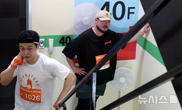 [서울=뉴시스] 추상철 기자 = 14일 오전 서울 영등포구 여의도 63빌딩에서 열린 '한화생명 시그니처 63 RUN' 행사에서 참가자가 40층을 지나며 쉬고 있다. 2025.06.14. scchoo@newsis.com