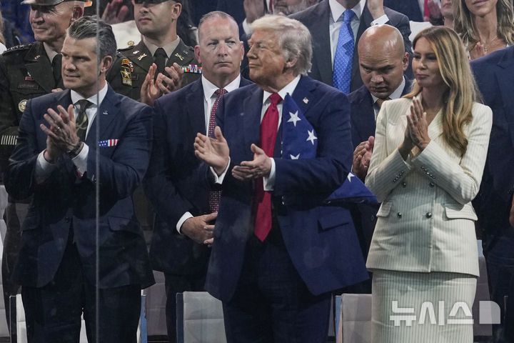 [워싱턴=AP/뉴시스]도널드 트럼프 미국 대통령이 부인인 멜라니아 여사와 14일(현지 시간) 미국 워싱턴DC에서 열린 미 육군 250주년 군사 퍼레이드를 지켜보며 박수치고 있다. 2025.06.15.