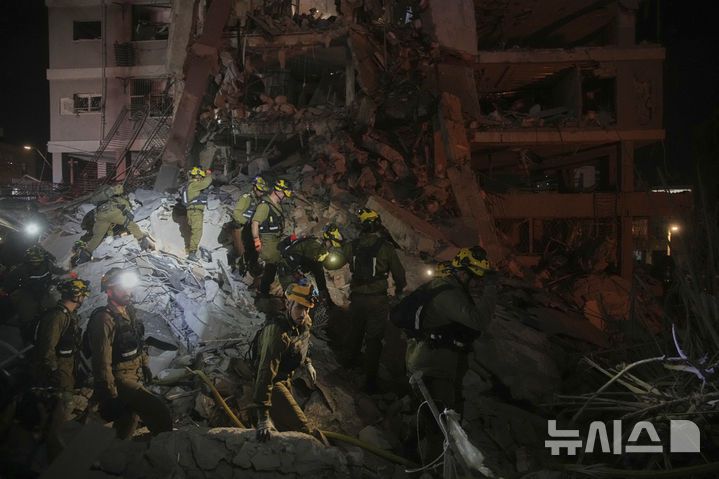 [텔아비브=AP/뉴시스] 15일(현지 시간) 이스라엘 텔아비브에서 이스라엘 군인들이 이란의 미사일 공격으로 파괴된 주거 건물 잔해 속 생존자를 수색하고 있다. 2025.06.16.