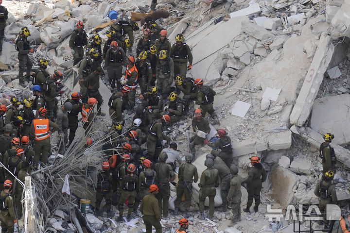 [바트얌=AP/뉴시스] 15일(현지 시간) 이스라엘 중부 바트얌에서 이스라엘 군인들이 이란의 미사일 공격으로 파괴된 주거 건물 잔해 속 생존자를 수색하고 있다. 2025.06.16.