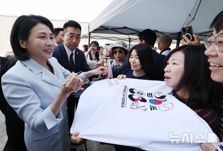 [캘거리=뉴시스] 최진석 기자 = 이재명 대통령 부인 김혜경 여사가 17일(현지 시간) 캐나다 앨버타주 캘거리 한인회관에서 열린 캐나다 서부 동포사회와의 대화를 나누기 전 인사하며 티셔츠에 싸인을 하고 있다. 2025.06.18. myjs@newsis.com