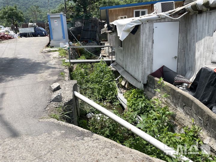 [서울=뉴시스] 이채은 인턴기자=19일 오전 서울 강남구 개포동 구룡마을 외곽의 배수로. 경사 지형임에도 쓰레기와 풀 등이 배수로를 덮고 있어 집중호우 시 수로 기능이 마비될 우려가 커 보인다. 2025.06.19