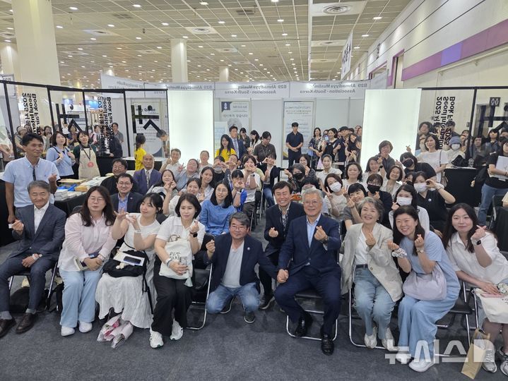 [서울=뉴시스] 조기용 기자 = 문재인 전 대통령이 19일 서울 강남구 코엑스에서 열린 서울국제도서전에서 시낭송회에 참석해 관람객과 기념 사진을 촬영하고 있다. 2025.06.19. excuseme@newsis.com