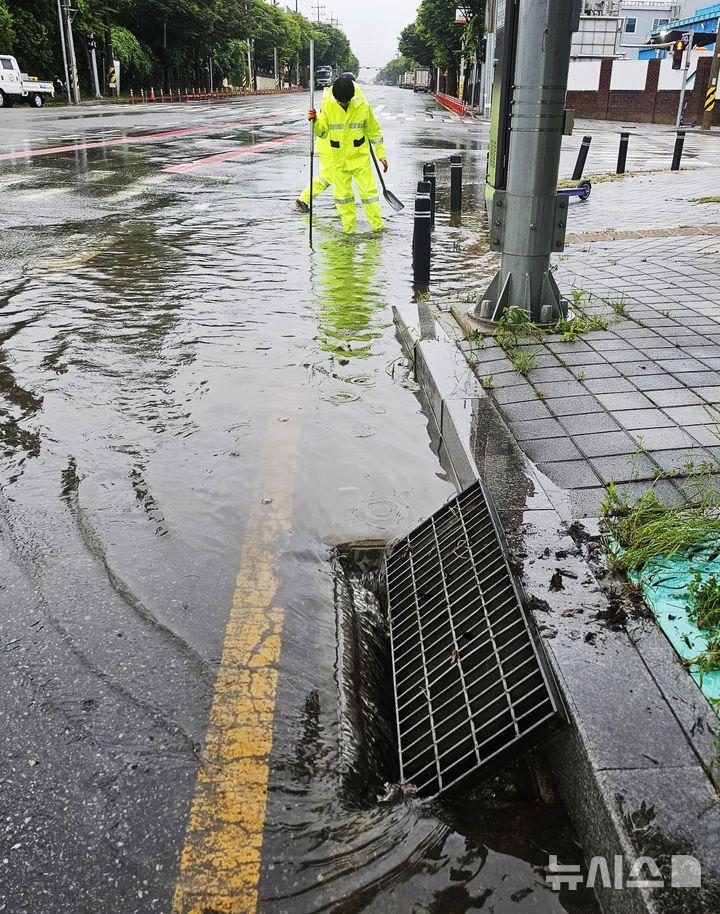 [광주=뉴시스] 박기웅 기자 = 장맛비가 내린 21일 광주 광산구 산월동 한 도로에서 광산구 직원들이 막힌 배수구를 뚫고 있다. (사진 = 광주 광산구 제공) 2025.06.21. photo@newsis.com *재판매 및 DB 금지