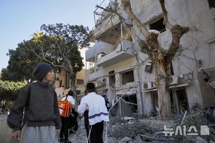 [하이파=AP/뉴시스] 22일(현지 시간) 이스라엘 하이파에서 주민들이 이란의 미사일 공격 현장을 살펴보고 있다. 2025.06.22.