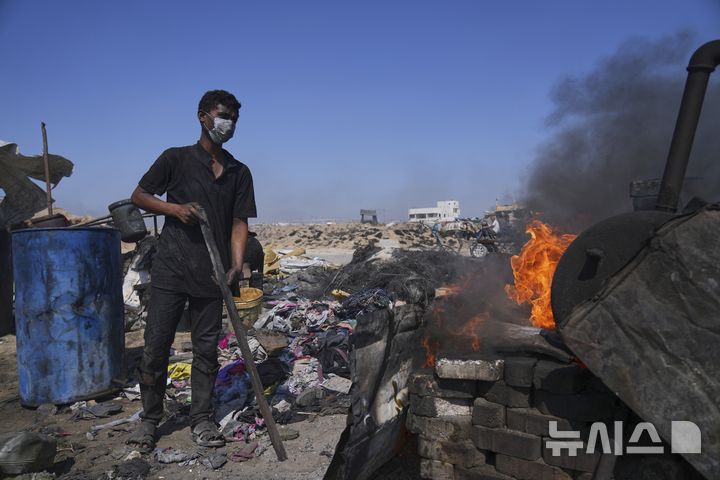 [가자시티=AP/뉴시스] 지난 22일(현지 시간) 가자지구 가자시티 남쪽 시로드에서 모하메드 나짐이라는 팔레스타인 청년이 플라스틱을 녹여 연료를 추출하기 위한 버너를 준비하고 있다. 팔레스타인 청년들은 플라스틱 폐기물을 금속 드럼에 넣고 가열해 만든 연료를 병에 담아 판매하며, 이는 현지에서 발전기나 이동용 연료로 사용된다. 유독한 연기와 불길에 노출되는 고된 작업이지만, 이들에게는 가족의 생계를 이어가는 거의 유일한 수단이다. 2025.06.25.
