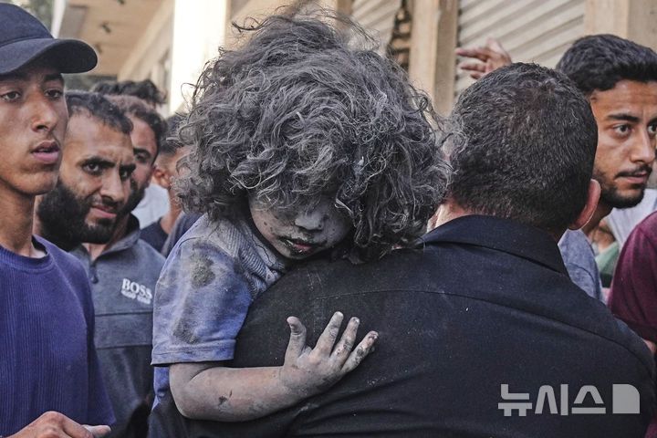 [가자시티=AP/뉴시스] 27일(현지 시간) 가자지구 가자시티에서 한 팔레스타인 남성이 이스라엘의 공습으로 부상한 아이를 안아 대피시키고 있다. 2025.06.27.