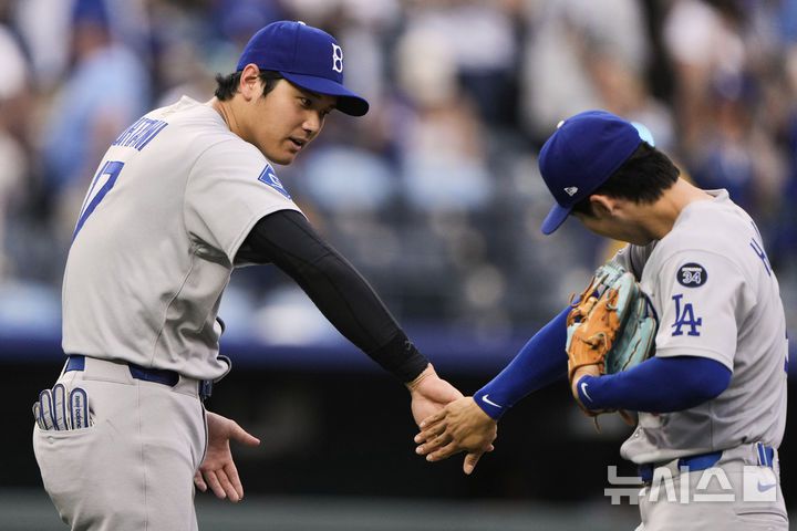 [캔자스시티=AP/뉴시스] LA 다저스의 김혜성(오른쪽)이 29일(현지 시간) 미 미주리주 캔자스시티 코프먼 스타디움에서 열린 2025 메이저리그 캔자스시티 로열스와의 경기를 마친 후 오타니 쇼헤이와 승리를 자축하고 있다. 김혜성은 8회 말 대수비로 나와 공격 기회는 없었고 다저스는 5-1로 승리했다. 2025.30.