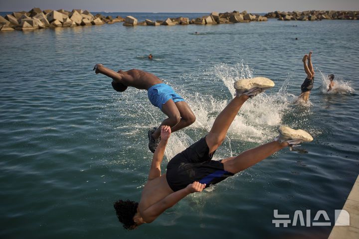 [바르셀로나=AP/뉴시스] 스페인에 무더위가 이어진 1일(현지 시간) 바르셀로나 해변에서 남성들이 물로 뛰어들고 있다. 2025.07.02.