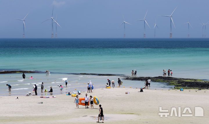 [제주=뉴시스] 우장호 기자 = 무더위가 기승을 부린 3일 오후 제주시 한림읍 협재해수욕장을 찾은 피서객들이 바닷물에 발을 담그며 더위를 식히고 있다. 기상청은 이날 제주 지역 장마가 사실상 지난달 26일 종료됐다고 발표했다. 올해 제주 장마 기간은 지난달 12~26일로 2주간이었으며, 이는 기상 관측 사상 가장 일찍 종료된 장마로 기록됐다. 2025.07.03. woo1223@newsis.com